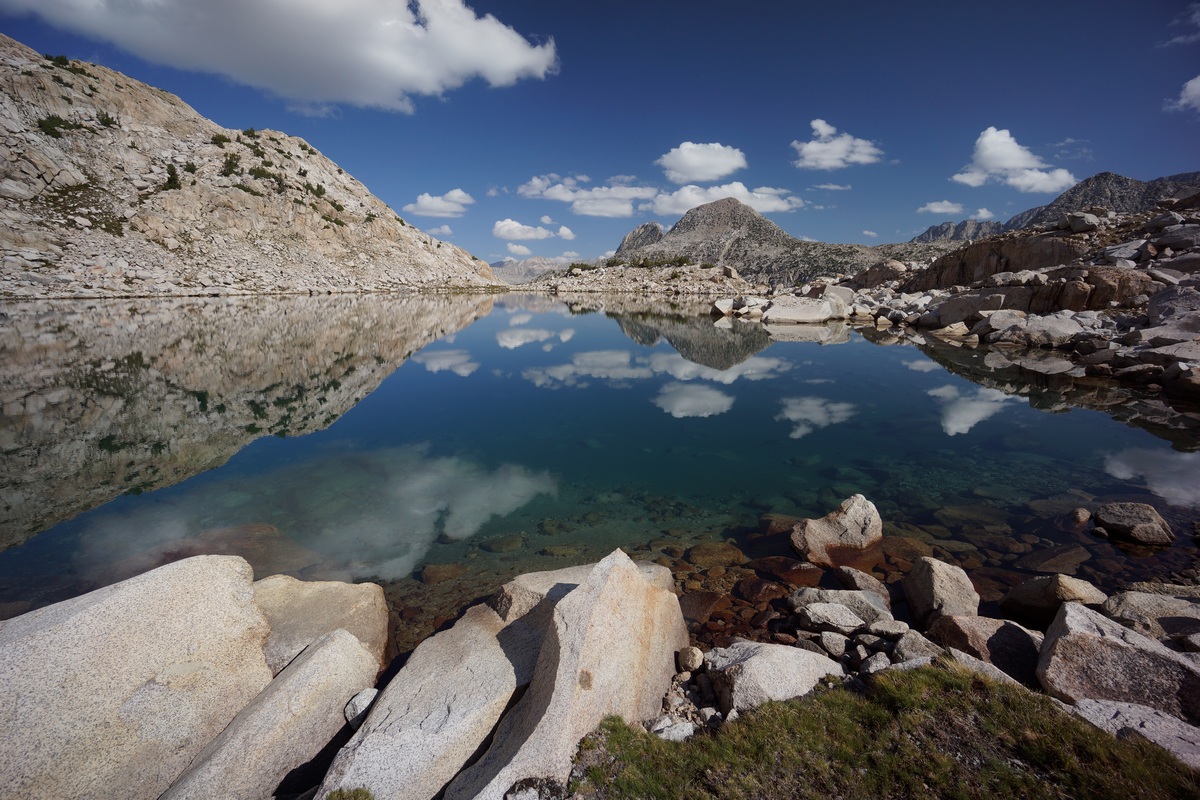 unnamed lake in upper mcgee canyon with clouds reflecting in blue water